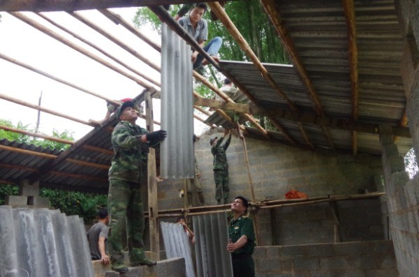 Cán bộ, chiến sĩ Đồn Biên phòng Cửa khẩu Trà Lĩnh giúp nhân dân xây dựng chuồng gia súc.